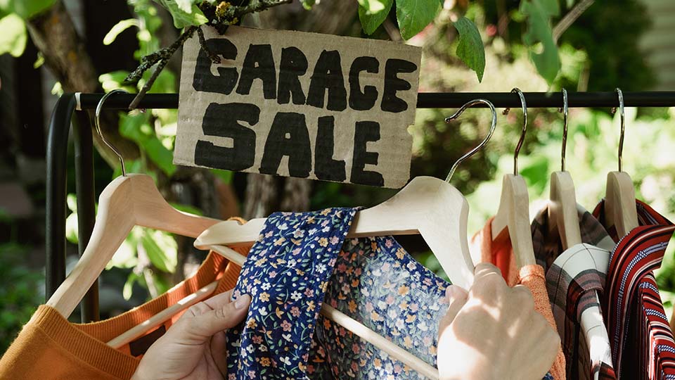 garage-sale-female-hands-picking-out-used-apparel-2023-11-27-05-22-17-utc
